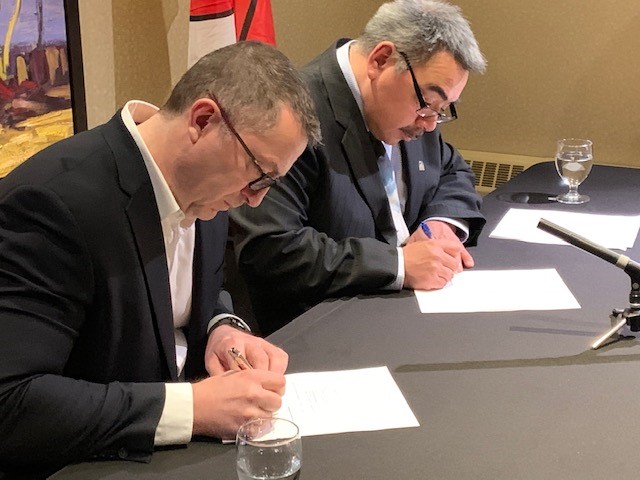 Brian Penney, President and CEO of Baffinland Iron Mines (Left) and David Akeeagok, Nunavut’s Minister of Economic Development sign an agreement on Tuesday April 2, to work together to maximize Inuit employment at the Mary River mine.